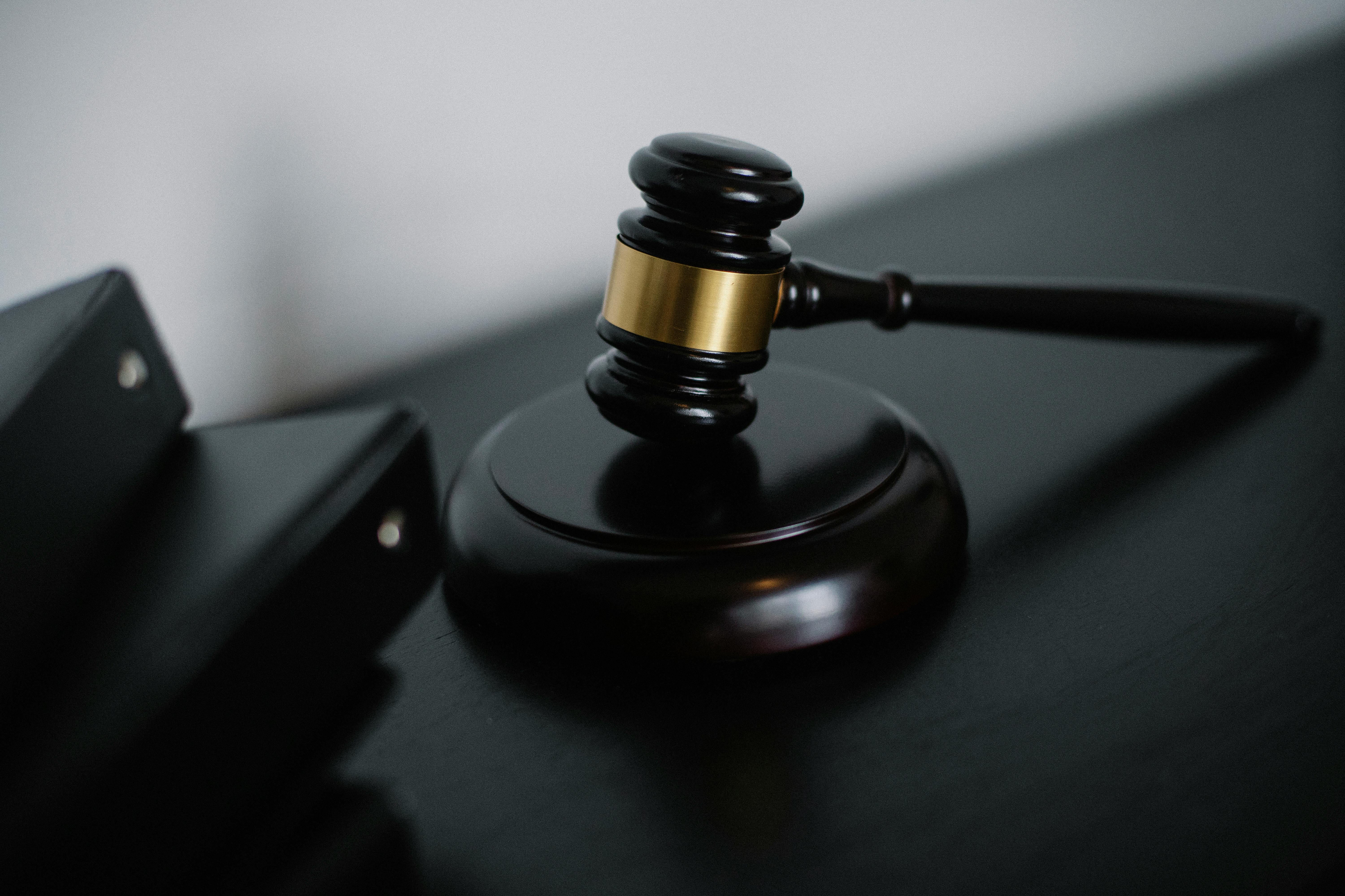 A judge's gavel resting on a dark surface